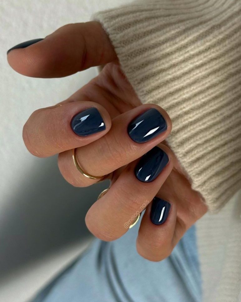 Short nails in glossy dark blue-grey, beige knit sleeve